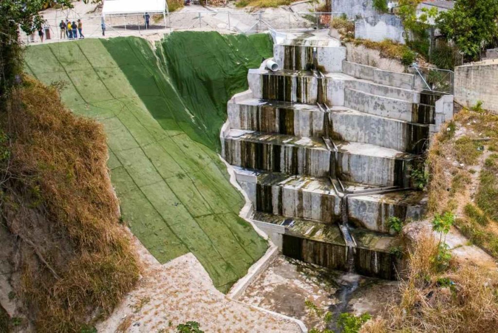 El proyecto incluyó la construcción de siete gradas de disipación para controlar aguas lluvias, drenajes, estabilización de taludes y la colocación de 1,800 metros cúbicos de lodocreto ciclópeo.