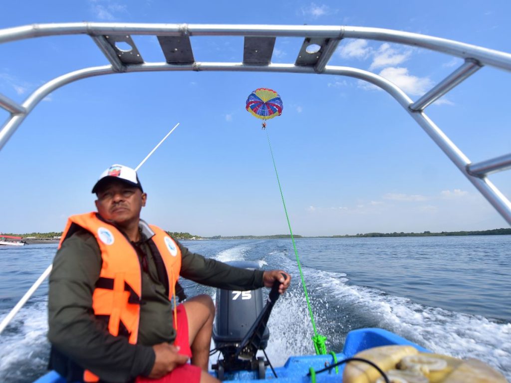Un operador dirige la lancha que impulsa el parasailing, generando la velocidad necesaria para que el paracaídas se eleve y el participante pueda volar sobre el mar.