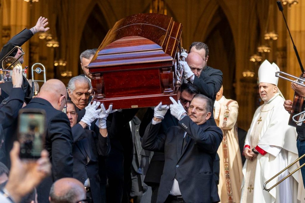Personas sostienen el féretro del cantante Willie Colón este lunes, al finalizar una misa pública con motivo de su funeral en la Catedral de San Patricio en Nueva York (Estados Unidos). EFE