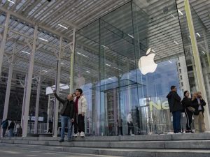 Personas se toman un foto en la entrada de la tienda Apple de la Quinta Avenida, el 30 de marzo de 2026, en Nueva York (Estados Unidos).