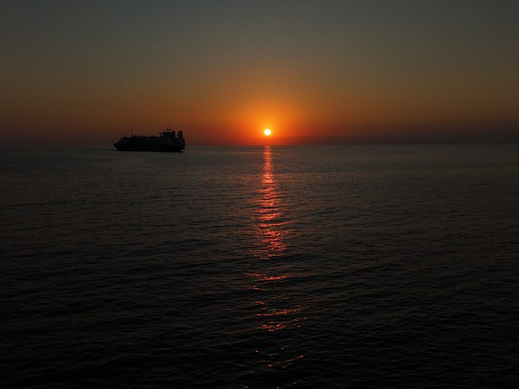 El atardecer en Acajutla pinta el horizonte sobre el Pacífico, mientras los barcos descansan frente a la costa.