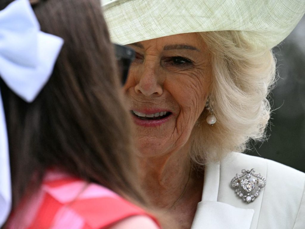 La reina Camila destaca con un broche histórico de diamantes que eleva su look blanco, durante una actividad juvenil en la Casa Blanca.