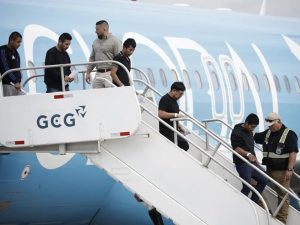 Fotografía de migrantes de distintas nacionalidades, procedentes de Estados Unidos, descienden de un avión este sábado, en el Aeropuerto Internacional Juan Santamaría, en San José (Costa Rica).