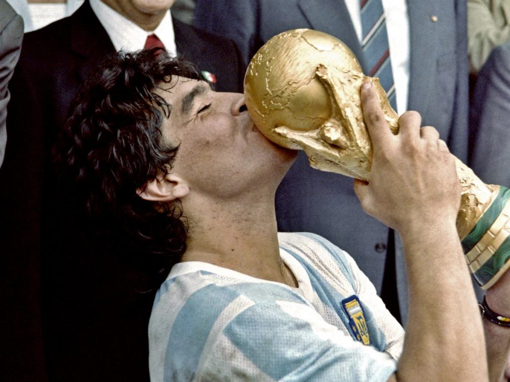 En esta foto tomada el 29 de junio de 1986, el capitán y estrella de la selección argentina de fútbol, ​​Diego Maradona, besa la Copa Mundial de Fútbol ganada por su equipo tras la victoria por 3-2 sobre Alemania Occidental en el estadio Azteca de la Ciudad de México. AFP