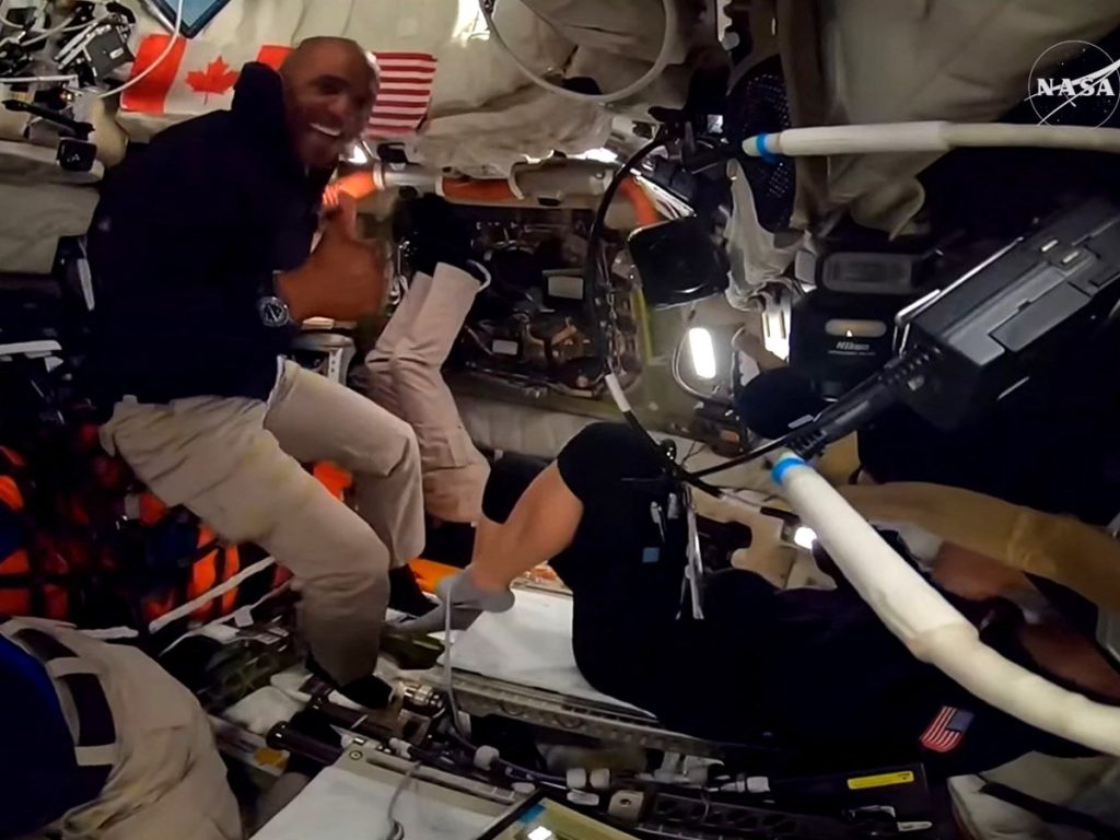 Esta captura de pantalla de una transmisión en vivo de la NASA muestra al astronauta de la NASA y piloto de Artemis II, Victor Glover, levantando el pulgar mientras el control de la misión en Houston informaba a los cuatro astronautas que habían pasado el punto medio entre la Tierra y la Luna en su camino hacia el sobrevuelo lunar planeado en la nave espacial Orion, el 3 de abril de 2026.