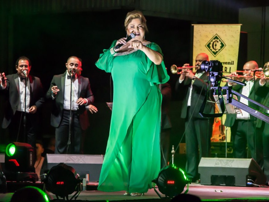 Nory Flores en el escenario, reflejando la evolución de su vestuario a lo largo de su carrera.