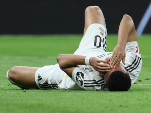 El delantero francés del Real Madrid, Kylian Mbappé, número 10, yace en el césped con sangre en la cara tras chocar con el defensa brasileño del Girona, Vitor Reis
