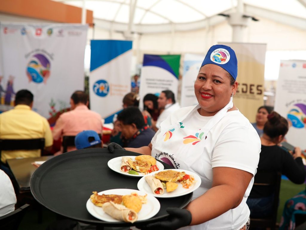 María Carranza sirve alimentos como parte del proyecto de seguridad alimentaria Manos que Alimentan. EFE