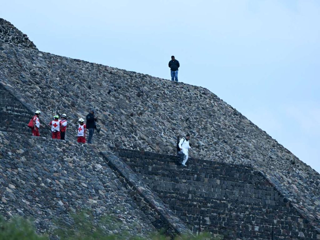 Expertos forenses y miembros de la Cruz Roja trasladan un cuerpo a la Pirámide de la Luna en la zona arqueológica de Teotihuacán tras un tiroteo ocurrido en Teotihuacán, Estado de México, el 20 de abril de 2026. AFP