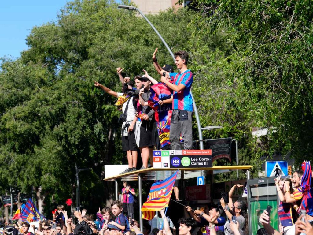 Aficionados saludan al paso de los jugadores del FC Barcelona durante la rúa con la que el equipo azulgrana festeja con su afición la consecución del título de campeón de LaLiga. EFE