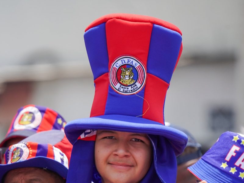 Un aficionado de FAS llama la atención con un enorme sombrero rojo y azul mientras alienta a su equipo en la previa del clásico nacional. Foto: cortesía La Primera