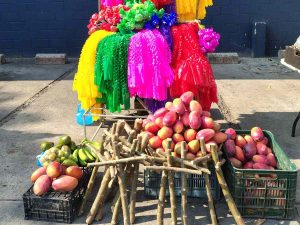 Cruz de jiote adornada con frutas y papel de colores, símbolo de abundancia y tradición en los hogares salvadoreños cada 3 de mayo.