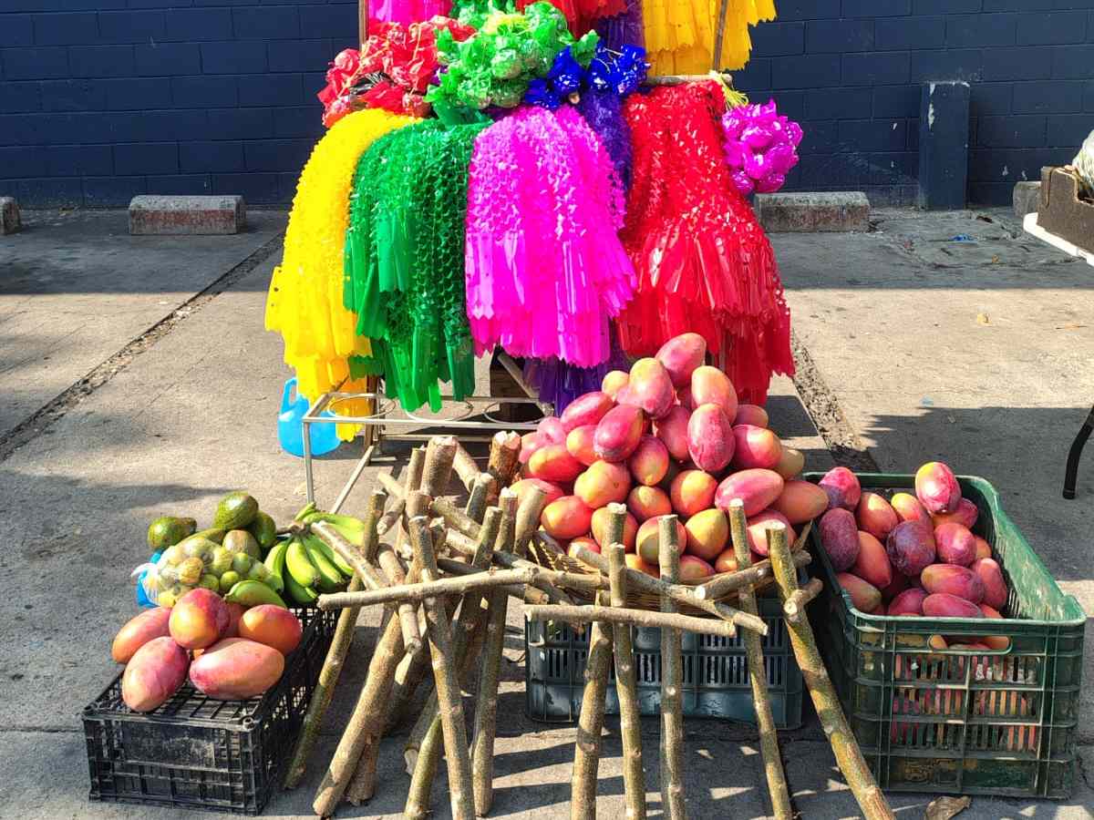Cruz de jiote adornada con frutas y papel de colores, símbolo de abundancia y tradición en los hogares salvadoreños cada 3 de mayo.