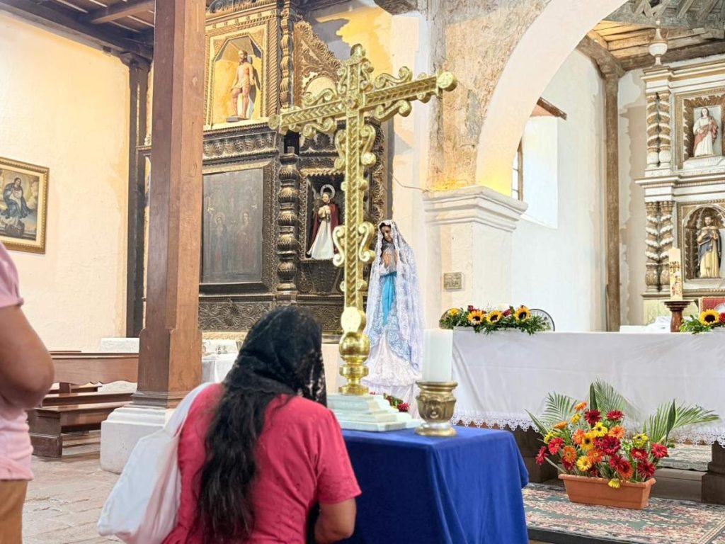 Feligreses hacen acto de reverencia ante la Cruz en la parroquia Santa Cruz de Roma.