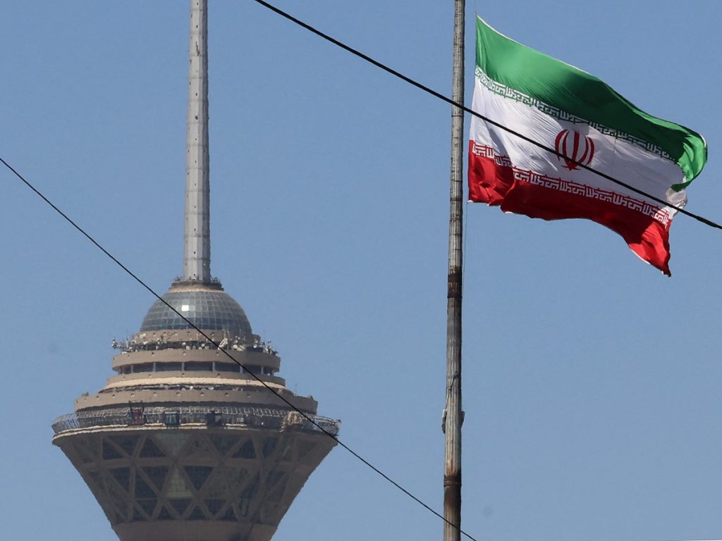 La bandera iraní ondea cerca de la Torre Milad, que forma parte del Centro Internacional de Comercio y Convenciones de Teherán, en la capital, el 25 de mayo de 2026. El