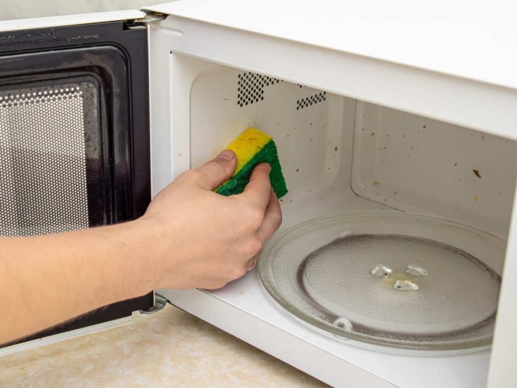 Limpiar el interior del microondas con una esponja ayuda a eliminar grasa y restos que, al recalentarse, generan malos olores y posibles contaminantes.