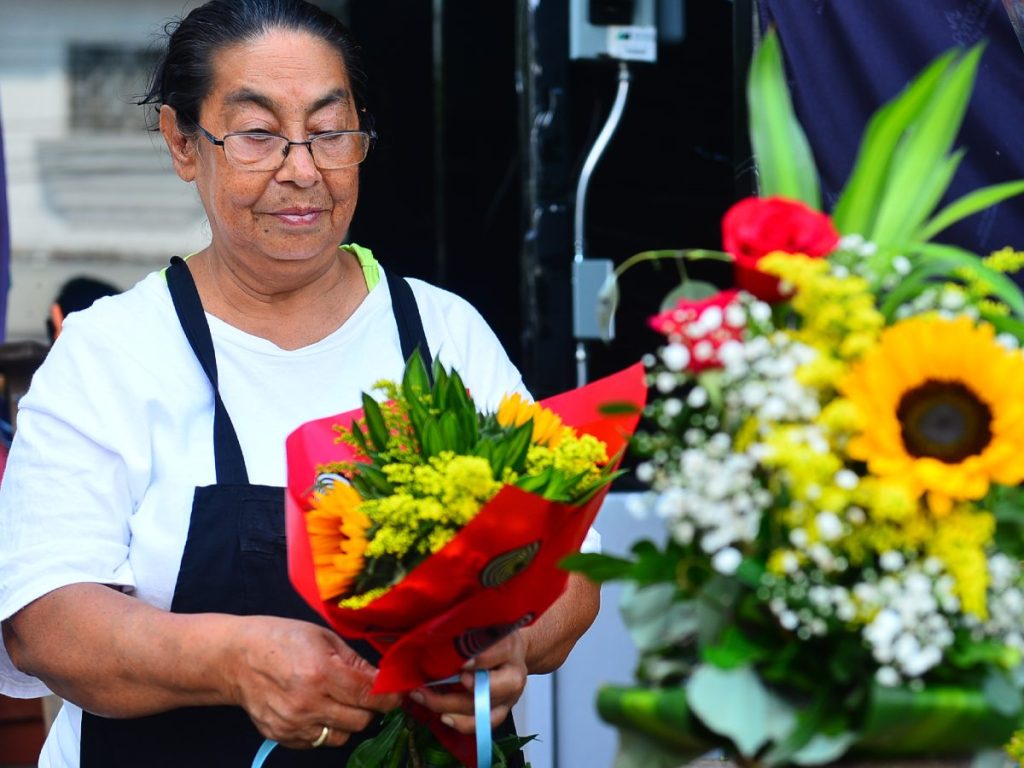 Teresa Espinoza acomoda arreglos florales en su puesto del mercado San Miguelito, siguiendo el legado que aprendió de su madre. Fotografía/ Lissette Monterrosa