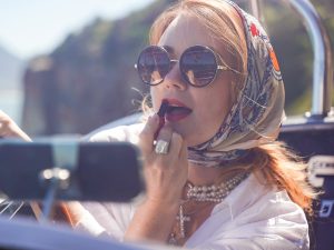 El pañuelo suma elegancia retro y funcionalidad: protege el cabello, enmarca el rostro y eleva un look blanco con aire chic.
