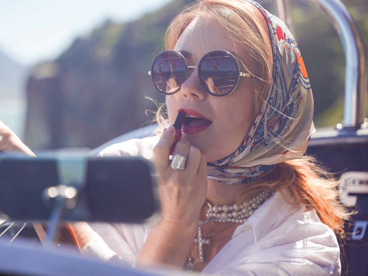 El pañuelo suma elegancia retro y funcionalidad: protege el cabello, enmarca el rostro y eleva un look blanco con aire chic.