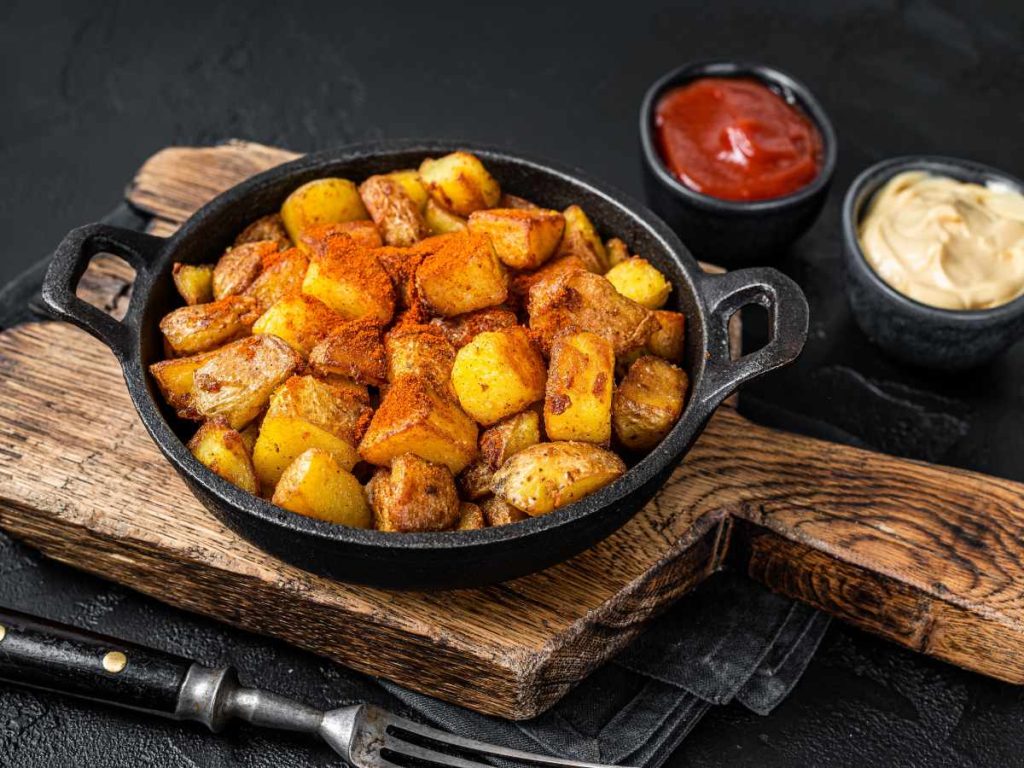 Las papas bravas ganan personalidad cuando combinan una cocción dorada, especias bien dosificadas y salsas que aportan contraste.