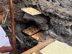 Turistas disfrutan una pizza cocinada con calor volcánico en las faldas del volcán Pacaya, en Guatemala.
