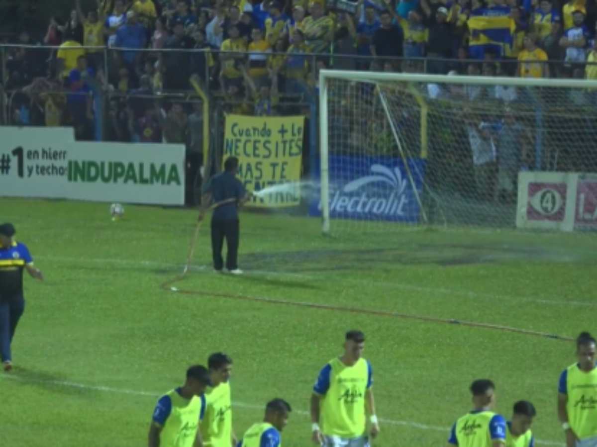 Trabajador riega la cancha del FAS