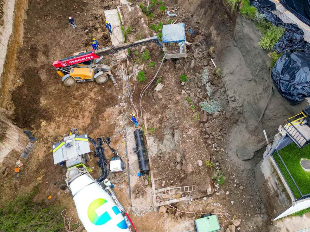 La intervención incluye la remoción de escombros con maquinaria pesada y la aplicación de concreto sobre la pantalla perimetral para reforzar la estabilidad de la zona afectada.