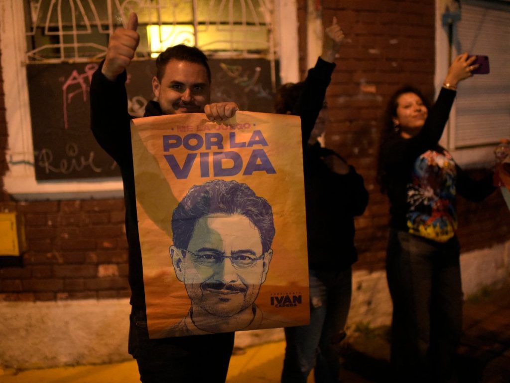 Un simpatizante sostiene un cartel que dice "Por la vida" con un retrato ilustrado del candidato presidencial colombiano Iván Cepeda durante una manifestación de partidarios del gobernante partido Pacto Histórico tras los resultados de la segunda vuelta electoral en Bogotá el 21 de junio de 2026.
