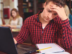 Male student studying at computer