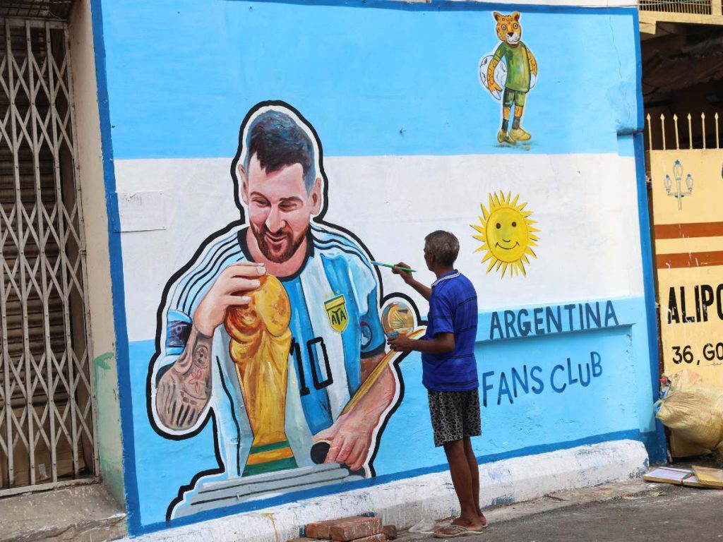 Un aficionado al fútbol pinta un mural del capitán argentino Lionel Messi en una pared de una calle de Calcuta, India, mientras el entusiasmo por la Copa Mundial de la FIFA se extiende por toda la ciudad.