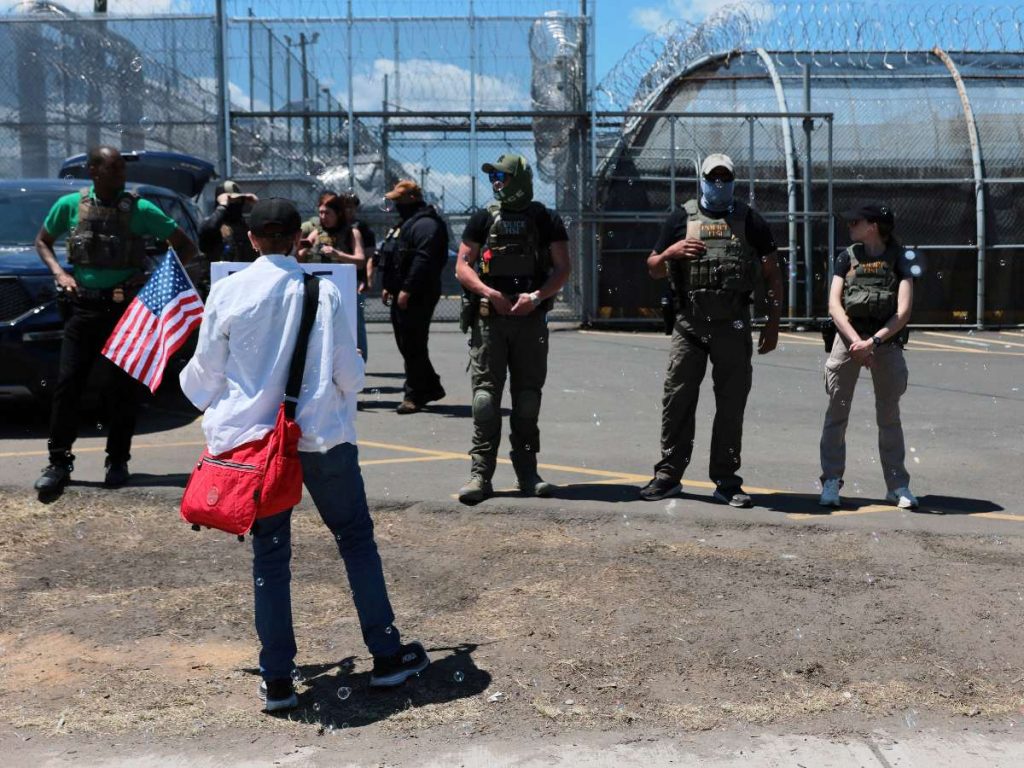 gentes del Servicio de Inmigración y Control de Aduanas (ICE) montan guardia frente a manifestantes en las afueras de Delaney Hall, centro de detención del ICE, el 29 de mayo de 2026 en Newark, Nueva Jersey.