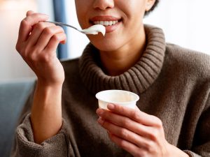 Una persona consume yogur, uno de los alimentos fermentados que puede aportar probióticos y contribuir al equilibrio de la microbiota intestinal.