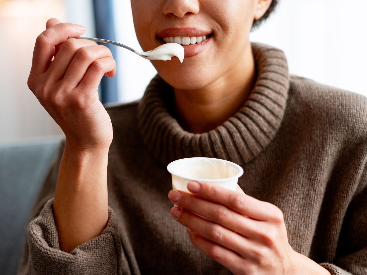 Una persona consume yogur, uno de los alimentos fermentados que puede aportar probióticos y contribuir al equilibrio de la microbiota intestinal.