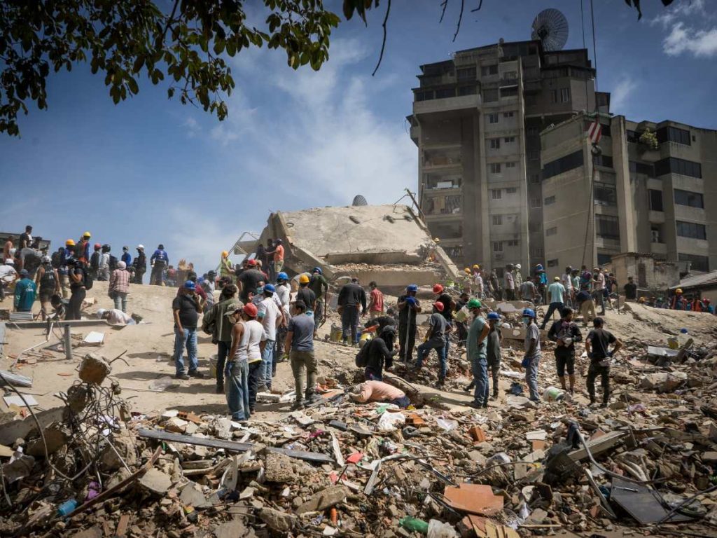 Rescatistas y voluntarios buscan víctimas en una vivienda afectada por los terremotos este jueves, en el municipio Libertador en el este de Caracas
