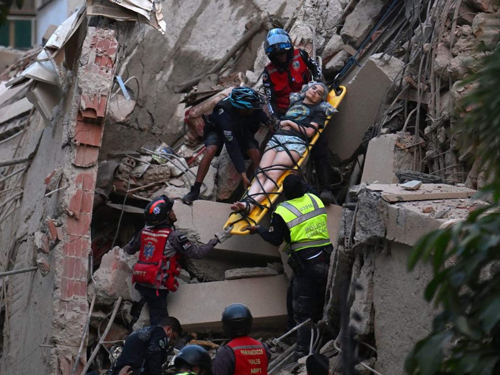 Los rescatistas sacan a una persona en camilla de un edificio derrumbado tras el terremoto que sacudió Caracas el 24 de junio de 2026.
