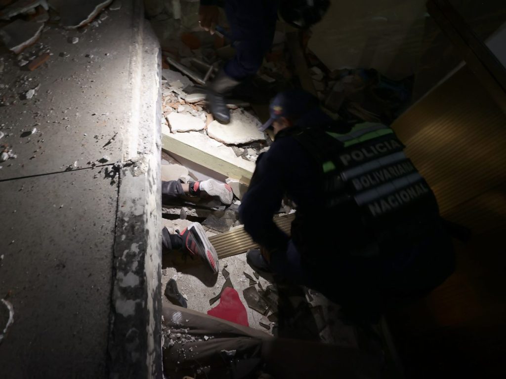 Integrantes del Cuerpo de Bomberos rescatan a una persona este miércoles, en Caracas (Venezuela).