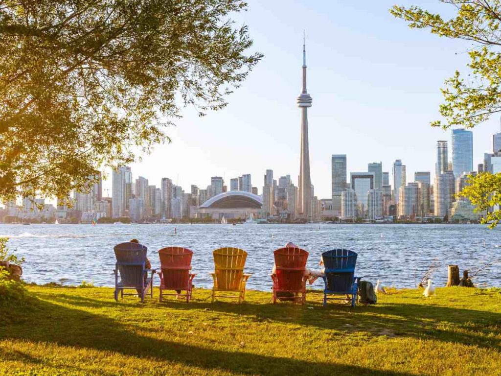 Sillas coloridas frente al lago Ontario, con el horizonte de Toronto al fondo, una de las vistas más emblemáticas de la ciudad canadiense.