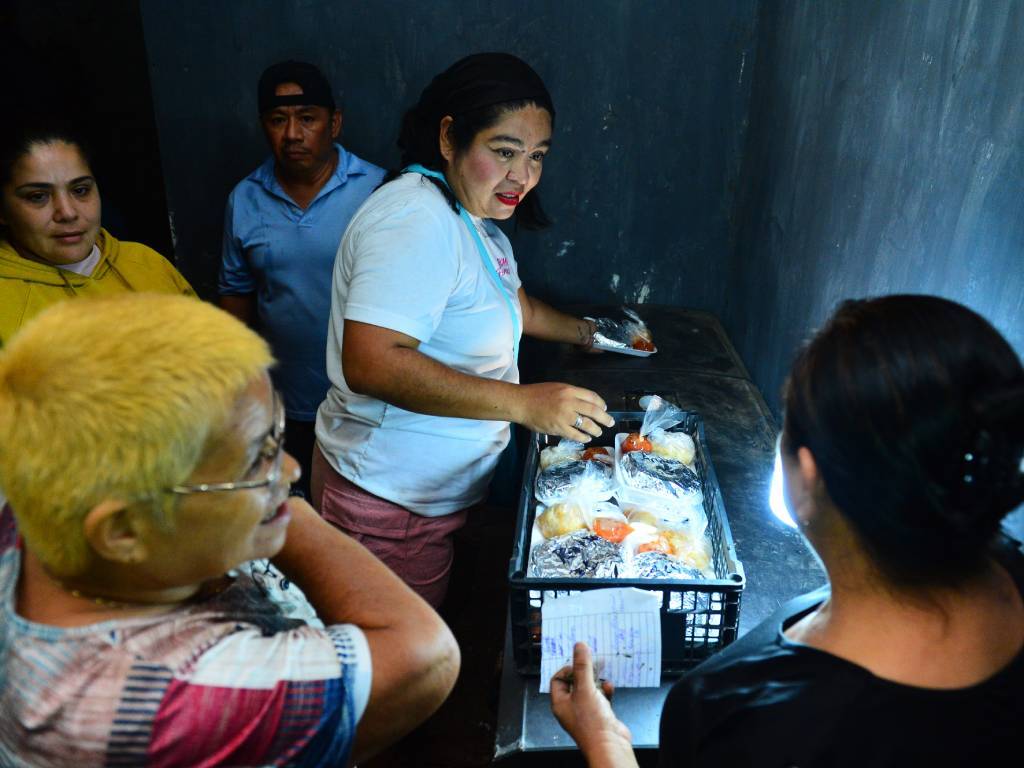 Personas cenan pupusas vendidas en el lugar.