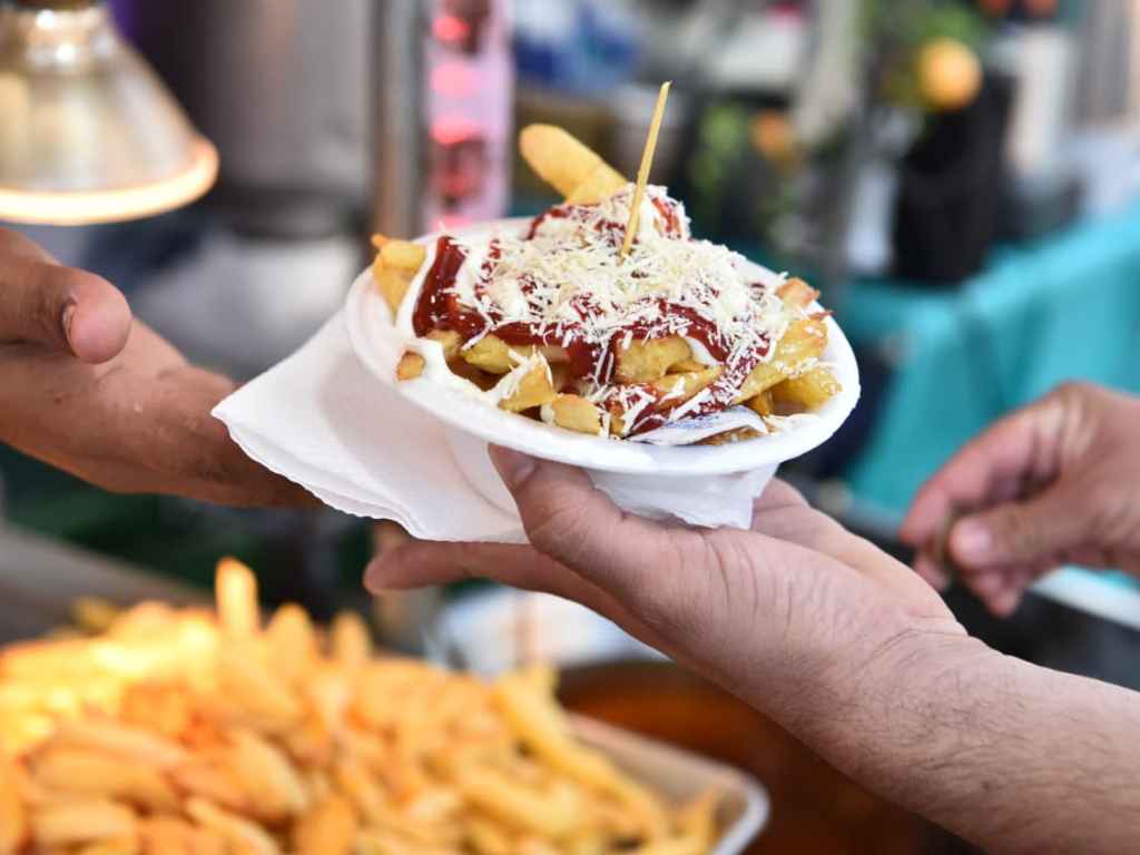 Deliciosas papas fritas con aderezos y queso rallado para disfrutar.