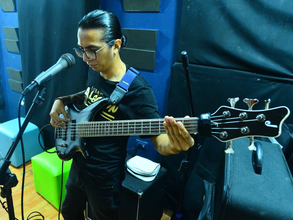 evin Ramos afina su bajo al integrarse como nuevo músico del grupo.