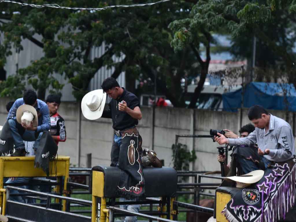 inetes orando con sombrero en mano antes de iniciar el jaripeo.