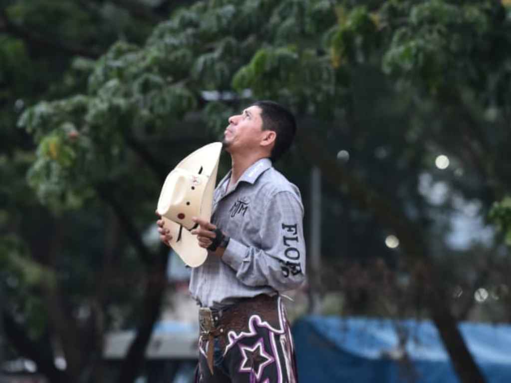 Orando con su sombrero en la mano para evitar una tragedia, un jinete mira hacia el cielo.