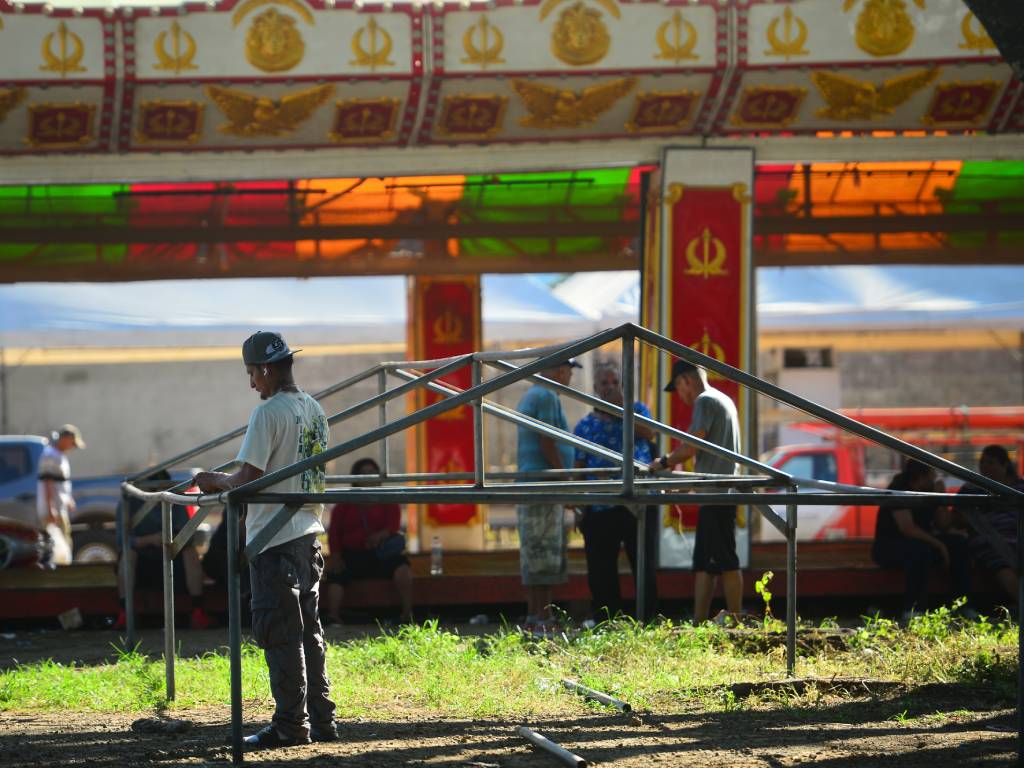 En la escena se distingue el montaje logístico previo a las Fiestas Julias: la instalación de las bases para las ruedas mecánicas, el espacio asignado a los circos internacionales, la delimitación de las áreas de parqueo y las hileras de puestos preparados para la venta de la gastronomía típica salvadoreña.