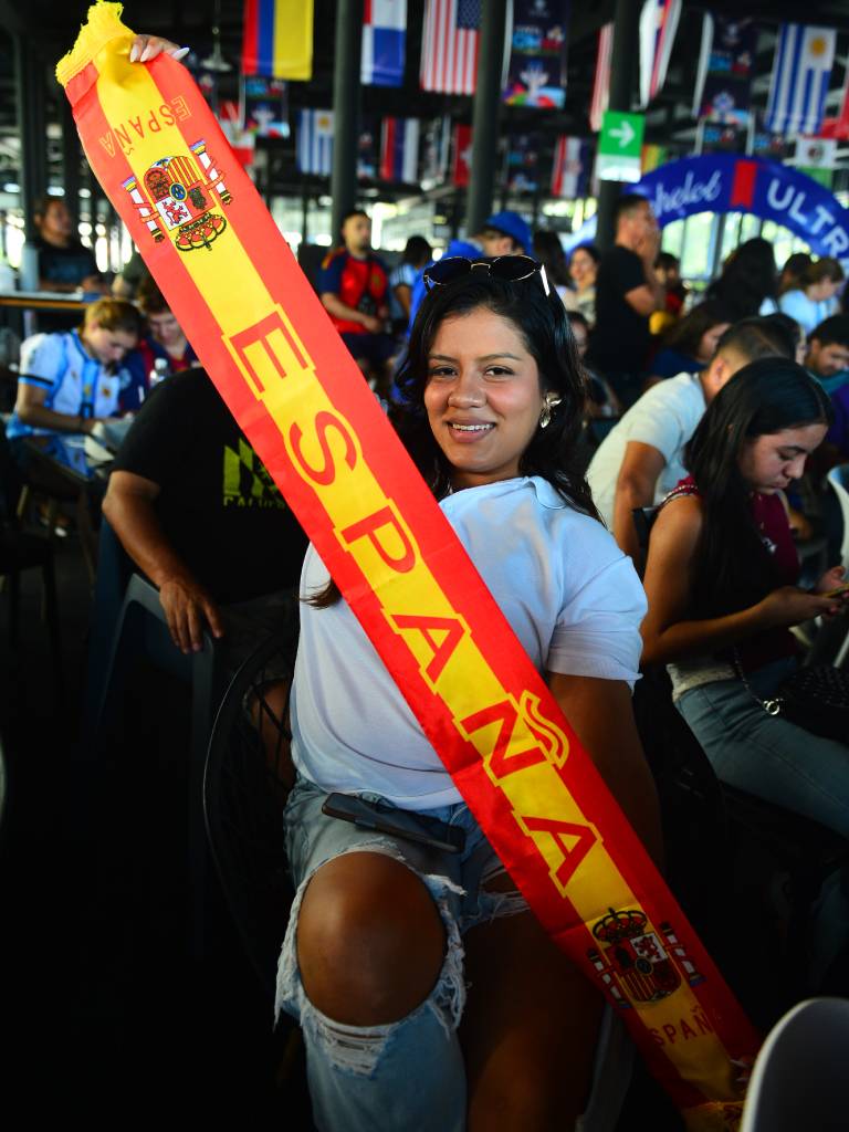 Melissa Ángel sostiene sonriente la bufanda de España.
