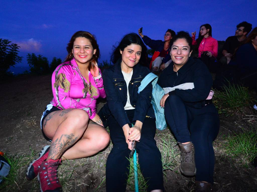 Complicidad en la naturaleza: Nadie se queda atrás. De izquierda a derecha, Frida Ramos, Priscila Barahona y Andrea Canjura sonríen y disfrutan de un momento de paz en un entorno natural rodeado de vegetación. La imagen captura el compañerismo y la tranquilidad en la montaña, reflejando la esencia de la comunidad Rumbo Femenino: un espacio seguro, solidario y sin competencias.