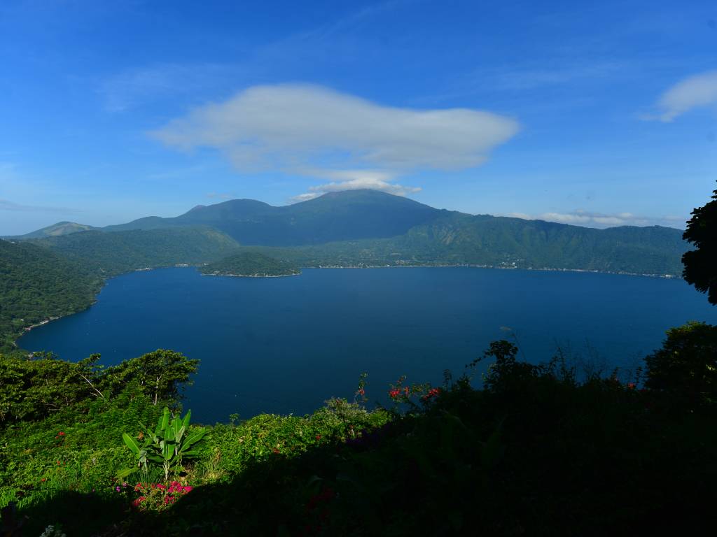 DESTINOS DE EL SALVADOR. Un grupo de mujeres desayunando frente a la vista panorámica del lago de Coatepeque en Santa Ana, El Salvador. Se detalla que este cuerpo de agua es un impresionante lago de origen volcánico ubicado a unos 18 kilómetros al sur de la ciudad de Santa Ana, entre los municipios de Santa Ana Centro y El Congo.