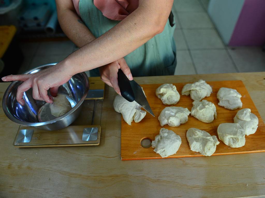 Artesana moldea con sus manos una hogaza de pan de masa madre.