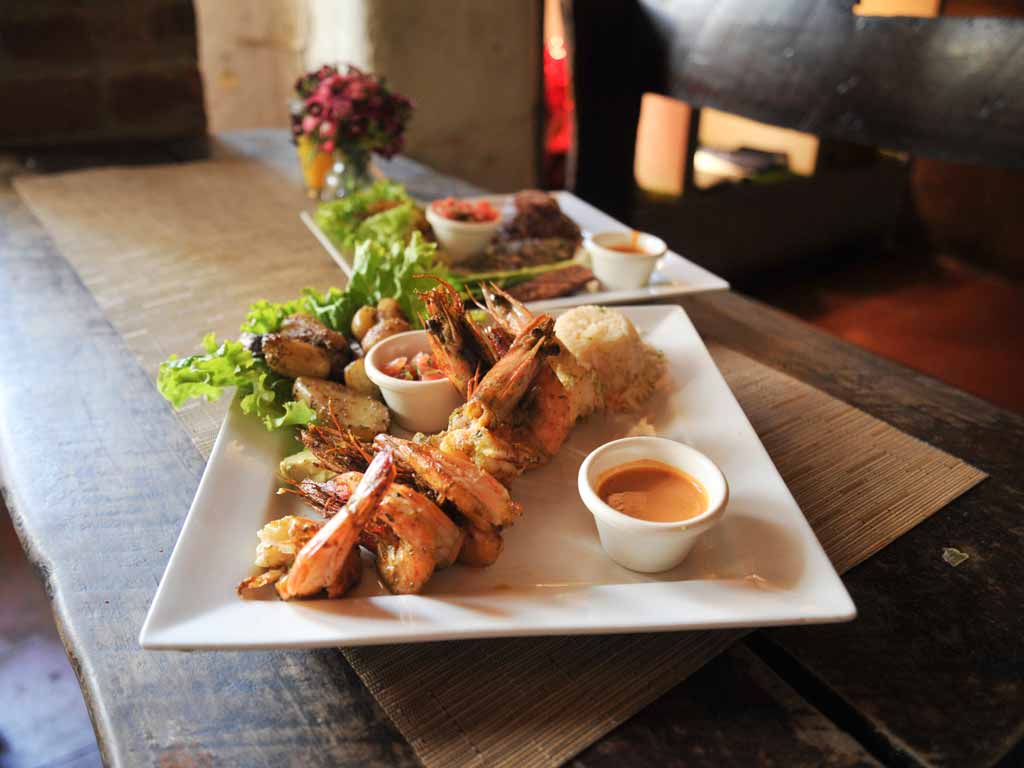 Brochetas de camarones con arroz y ensalada fresca.