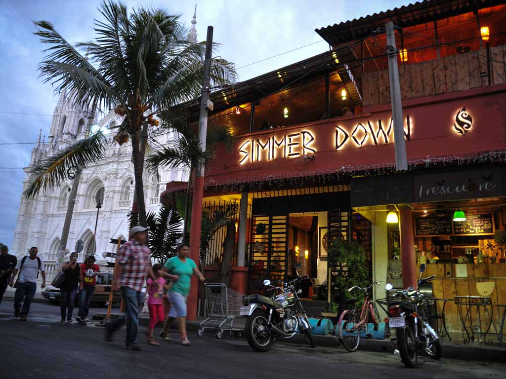 Fachada iluminada de Simmer Down con la Catedral al fondo.