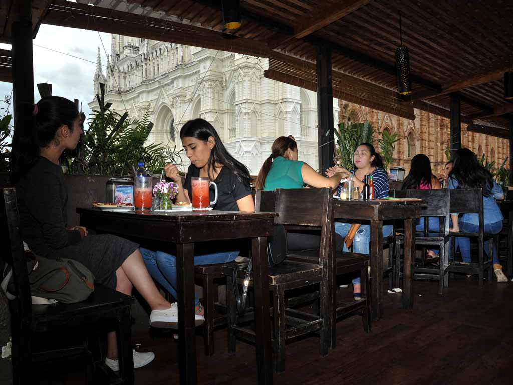 Clientes cenando en la terraza con la Catedral de fondo.